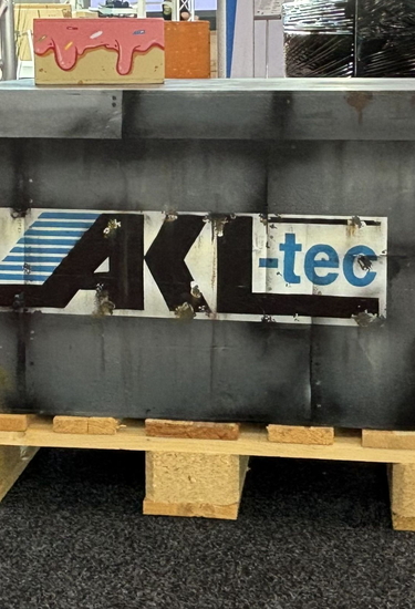 Eine schwarze Transportkiste mit AKL-tec auf einer Palette