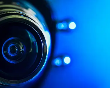 Gros plan d'un objectif d'appareil photo sur fond bleu