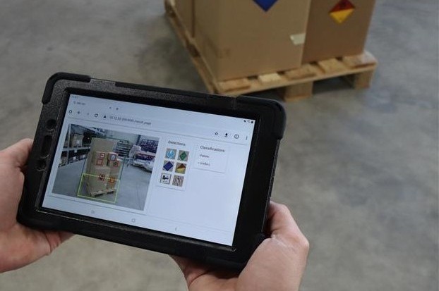 Employee holds tablet in hand and sees boxes and how Predictive Vision for Logistics works